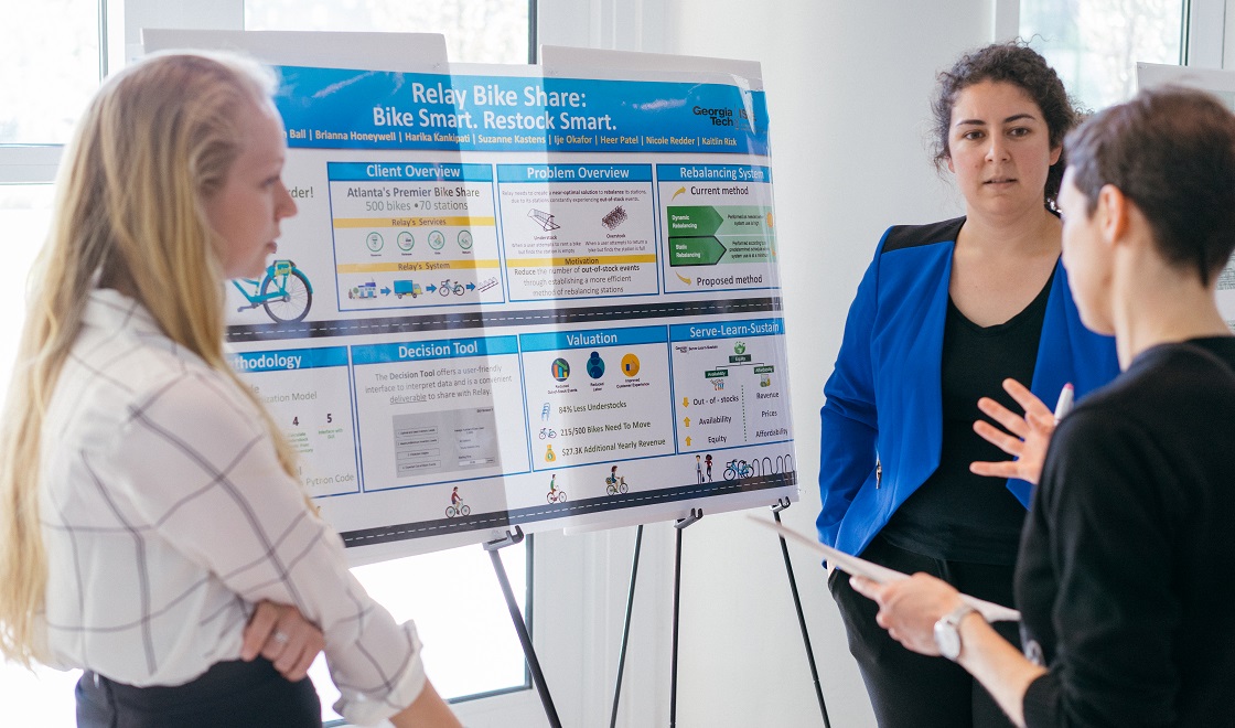 Three woman in front of a presentation board