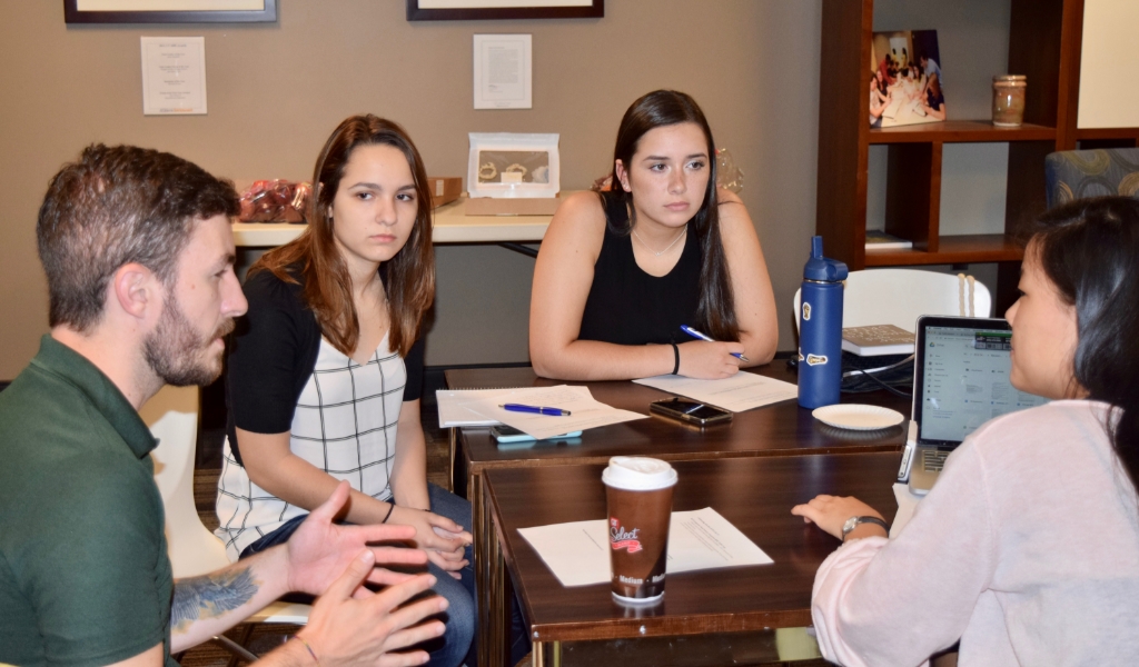 Students having discussion while sitting at table